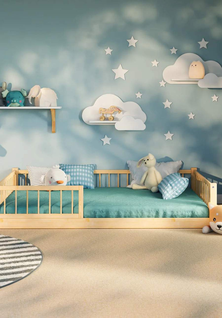 Snuglee Montessori wooden floor bed with safety rails for toddlers, set in a calming blue nursery with cloud decorations and soft toys